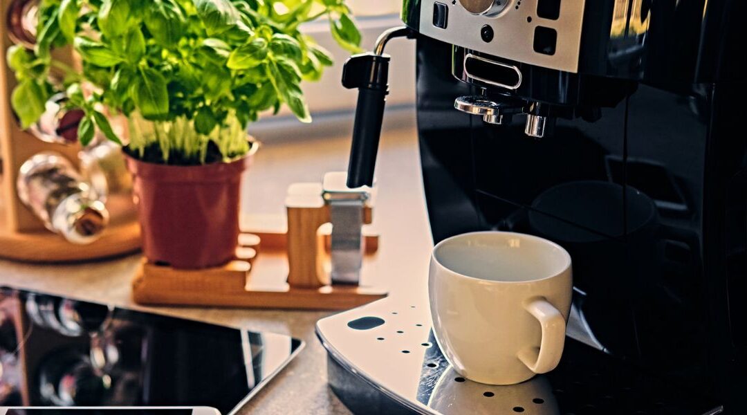 Spice rack, plant, tablet in background. Coffee machine and white mug.