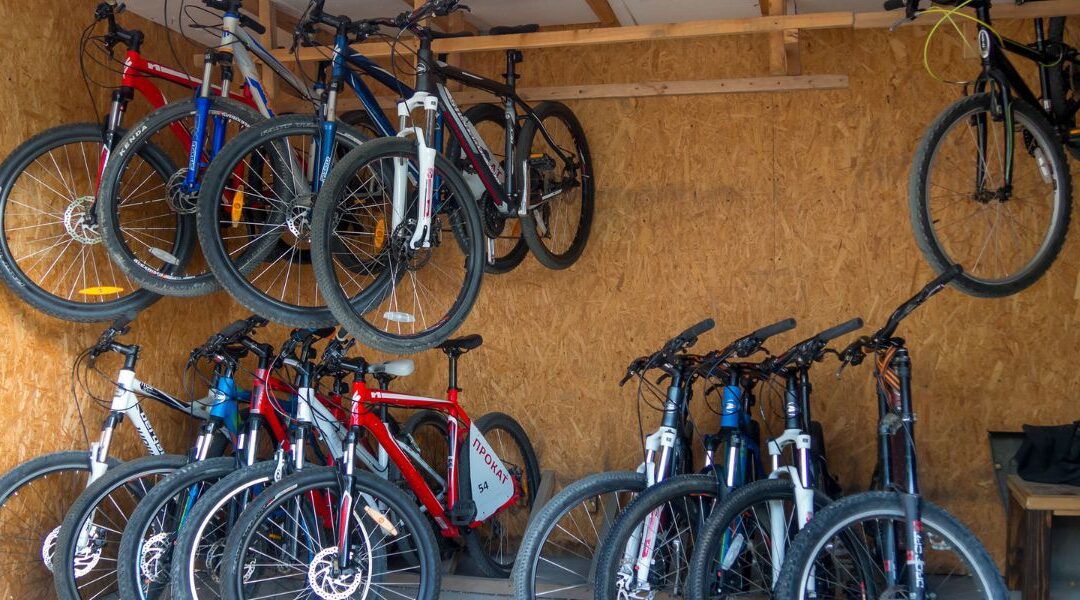 bikes hanging on shed ceiling with several bikes stood up under them